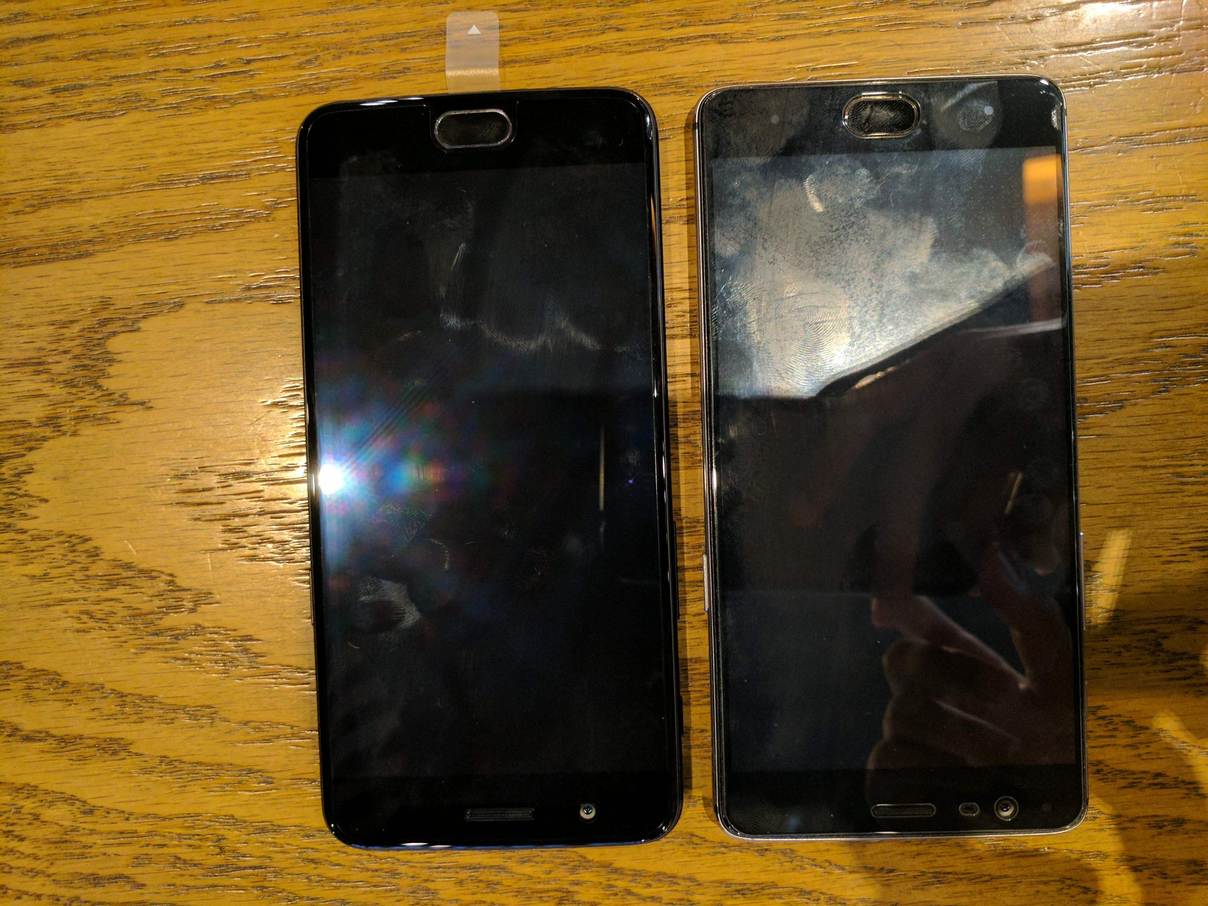Dua telefon dengan kesan cap jari pada permukaan skrin