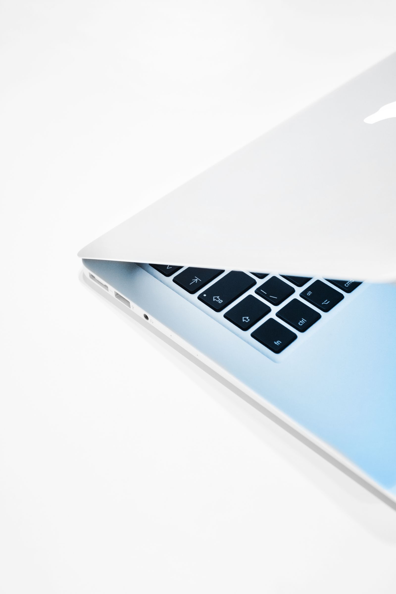MacBook dibuka sedikit di atas permukaan putih