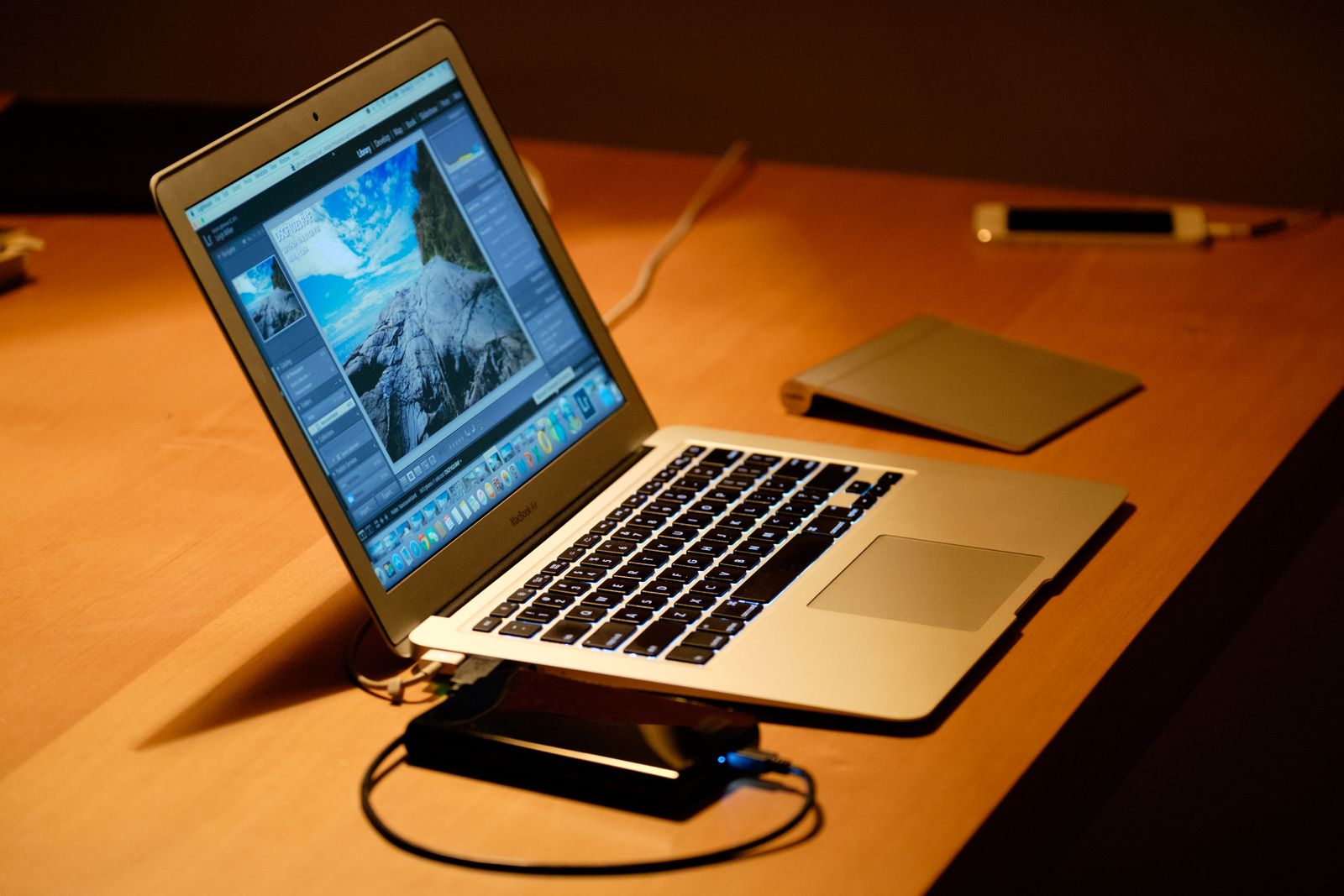 MacBook yang terbuka di atas meja kayu