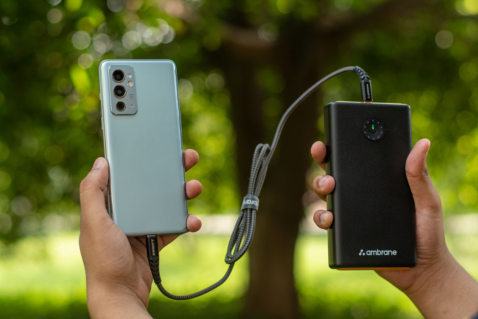 Pengguna memegang telefon dan bank kuasa yang disambungkan