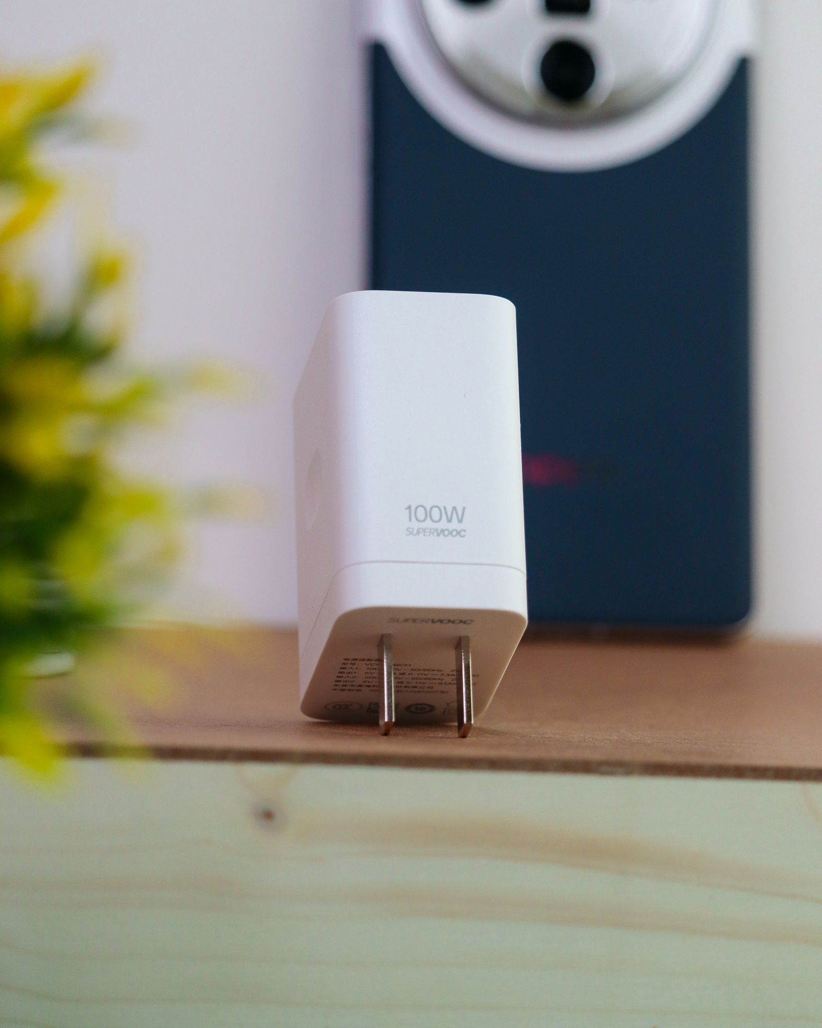 Pengecas berlabel 100W SuperVOOC dengan telefon di belakang