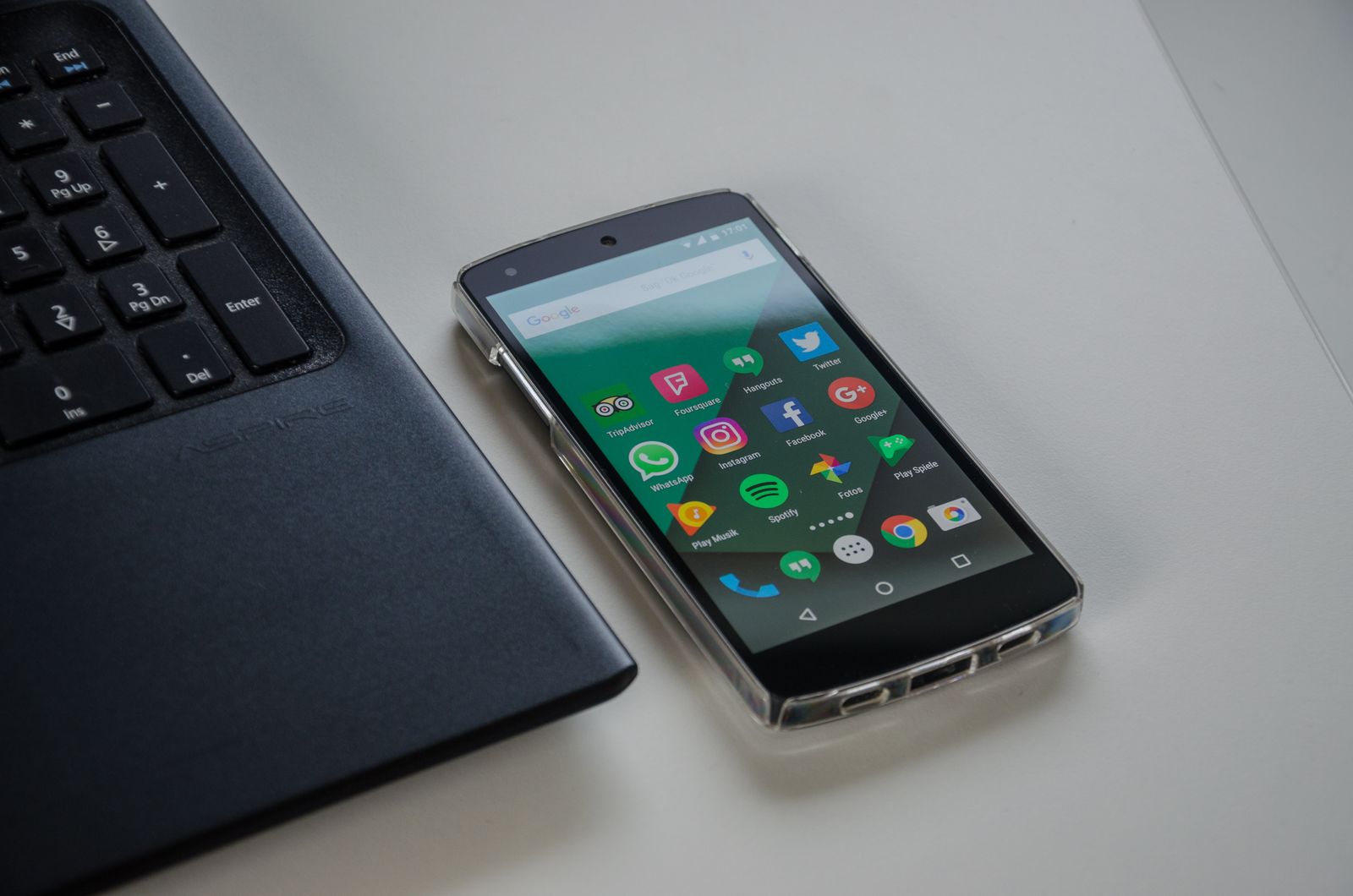 Telefon Android di atas meja berhampiran komputer riba