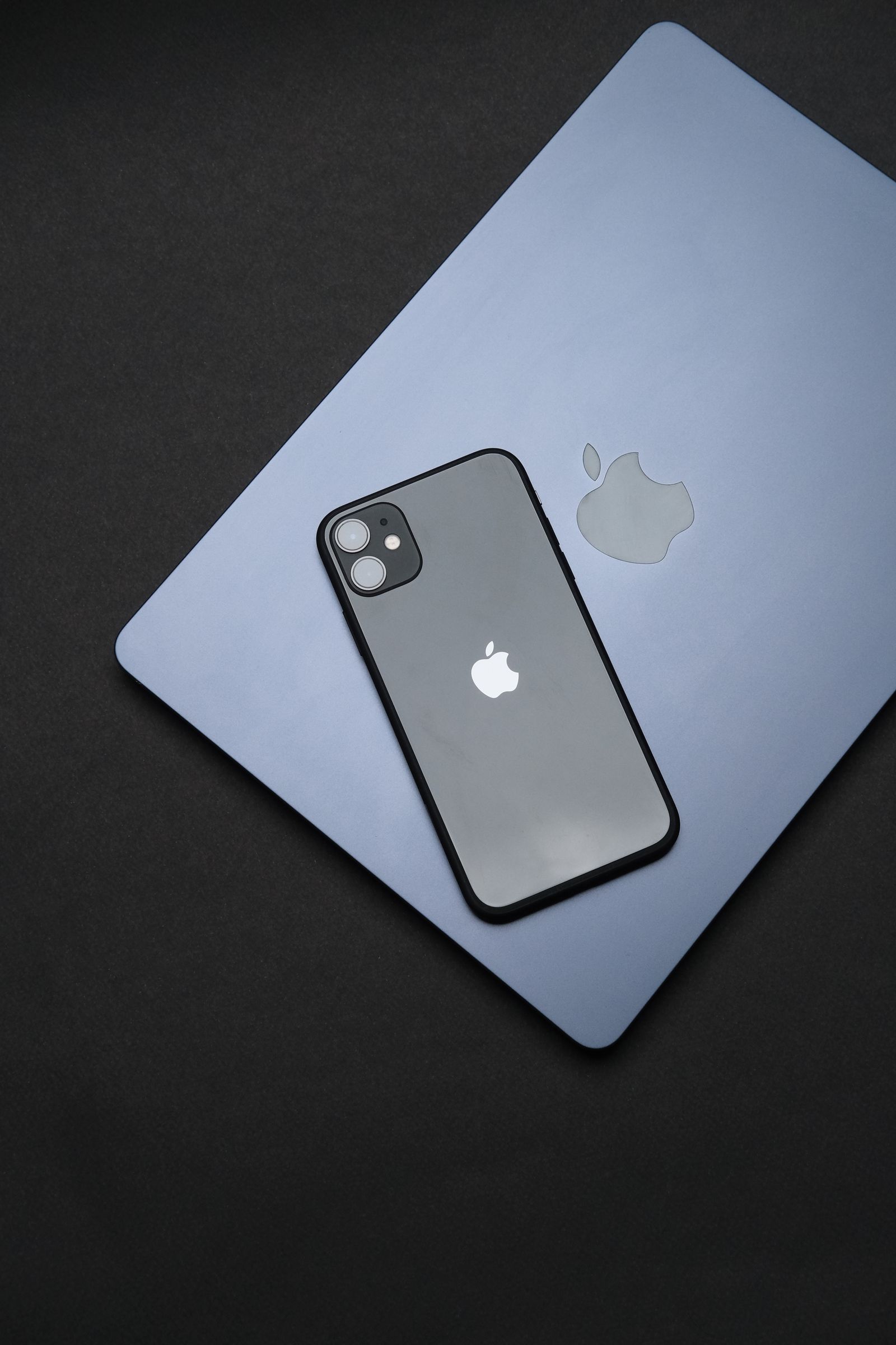 iPhone dan MacBook di atas permukaan gelap