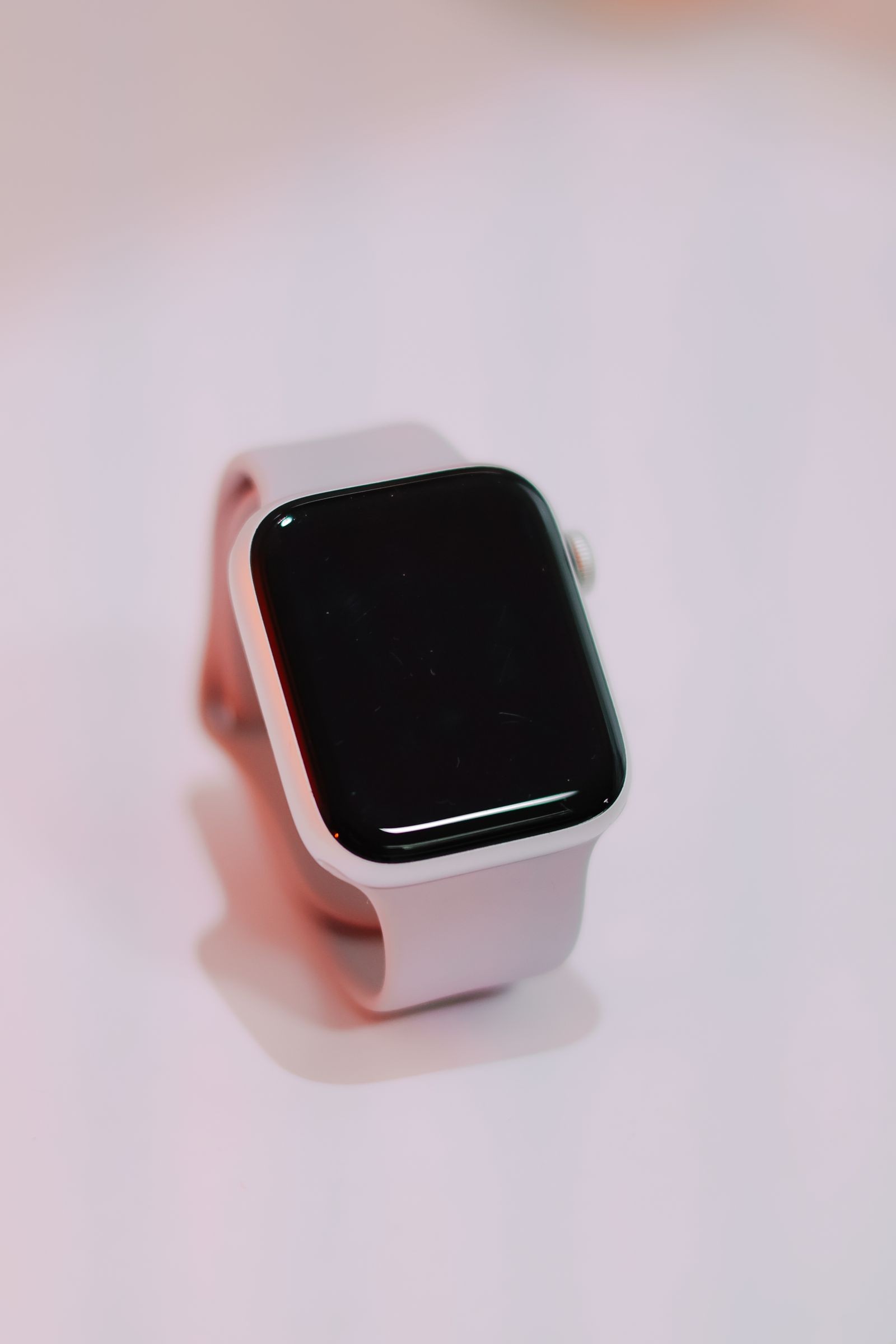 Jam pintar dengan tali cerah di atas permukaan merah jambu
