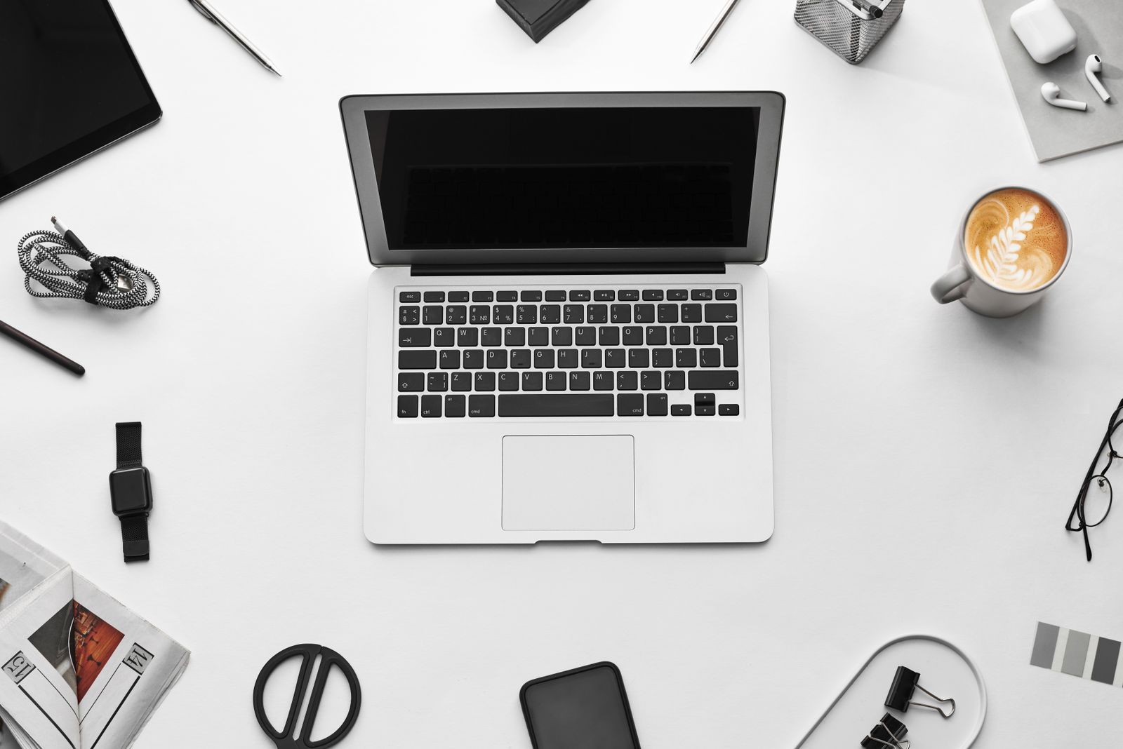 MacBook dan aksesori di atas meja kerja