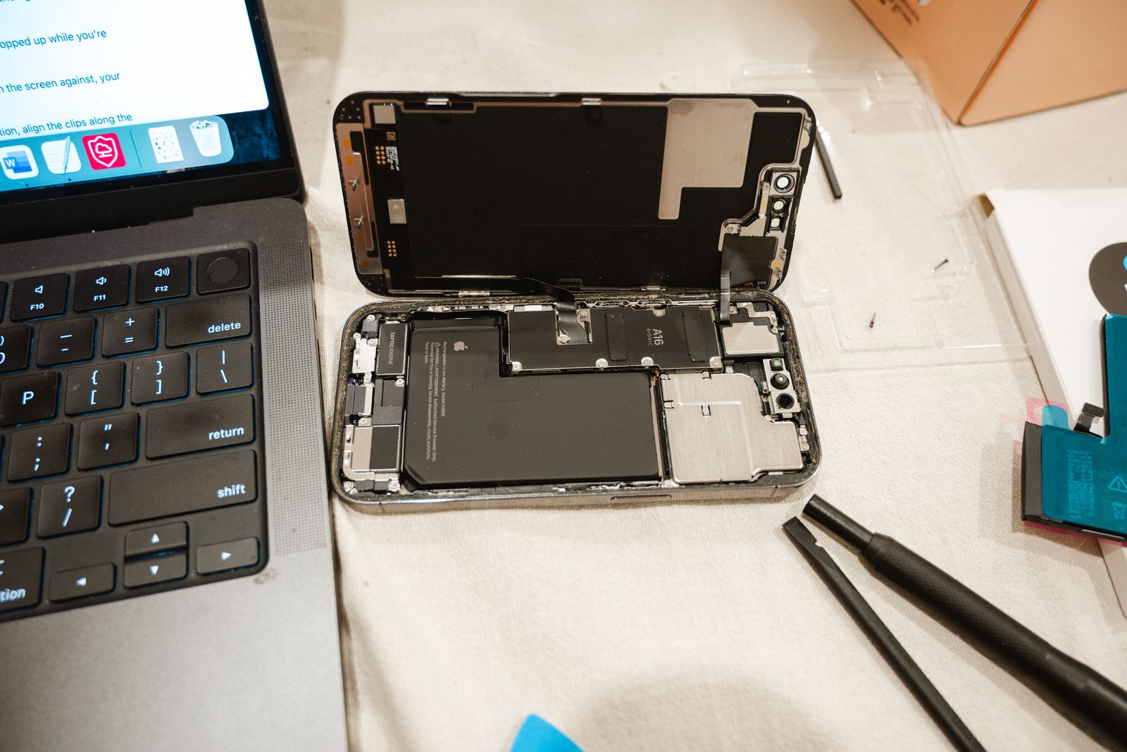 Telefon dibuka bersama alat pembaikan di atas meja