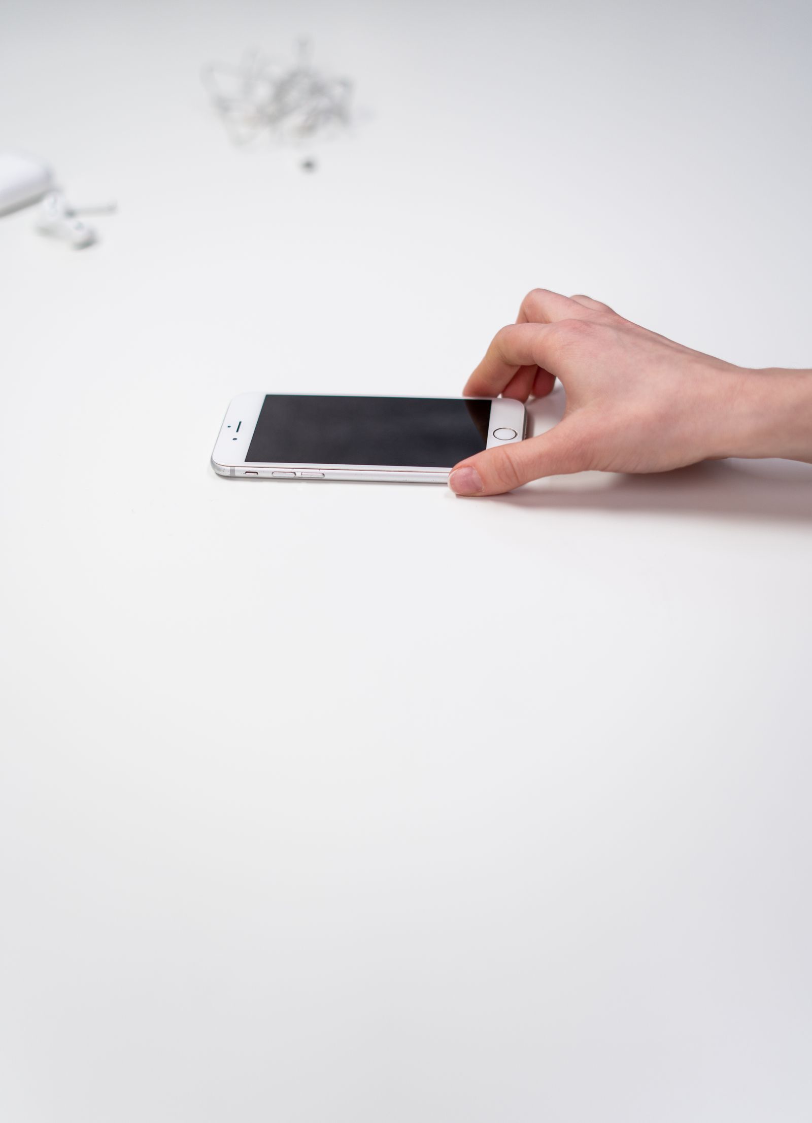 Tangan menyentuh skrin telefon di atas meja