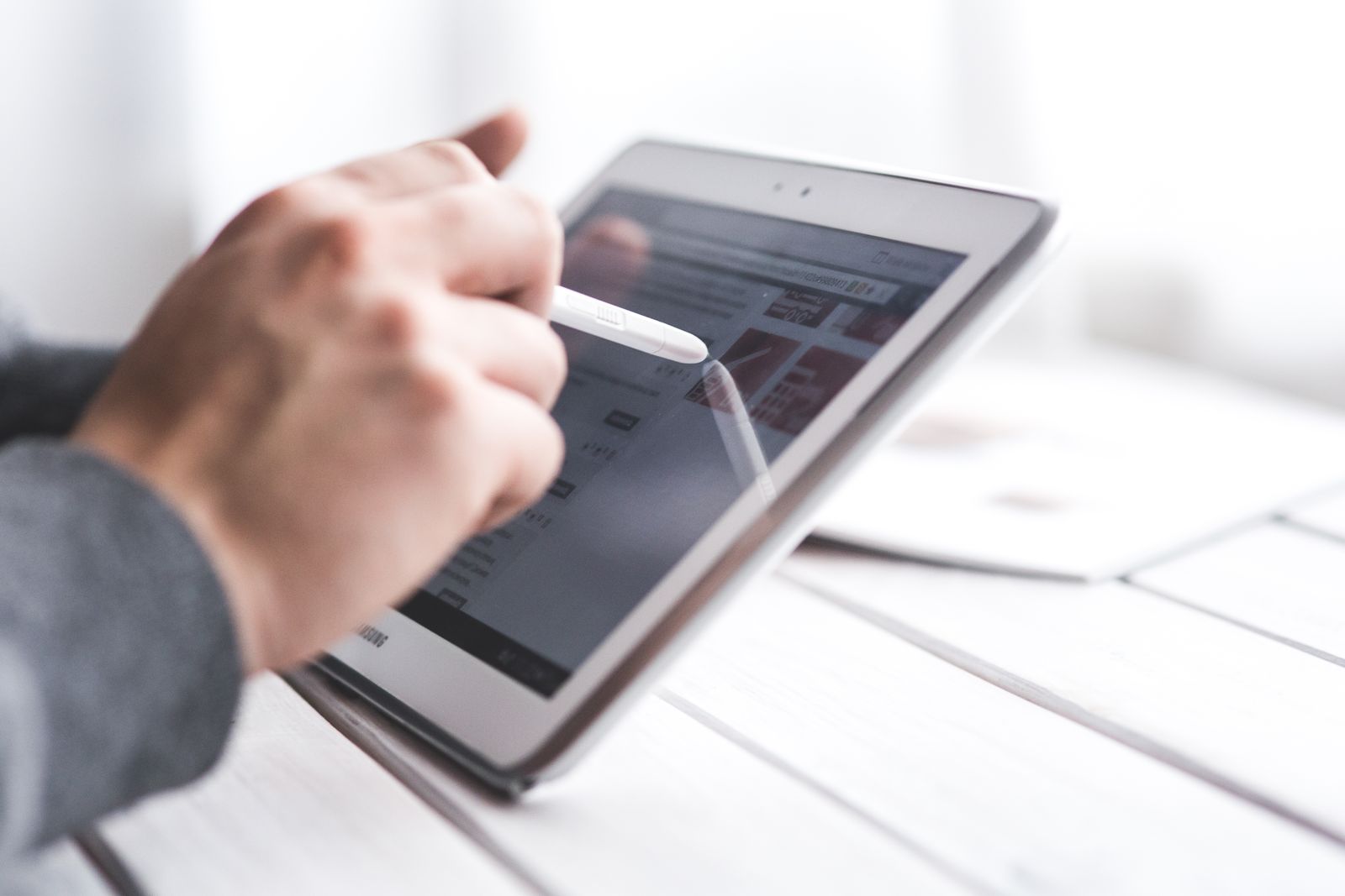 Pengguna menyentuh paparan tablet dengan stilus