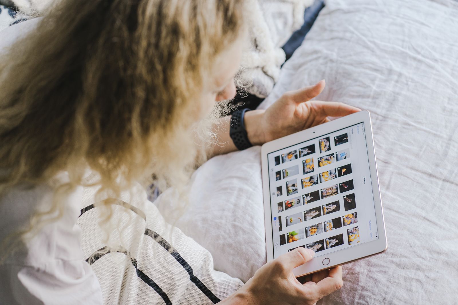 Pengguna melihat koleksi gambar pada tablet