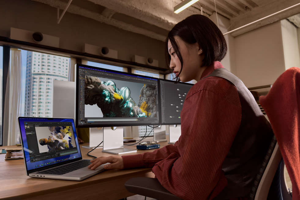 Pengguna MacBook Pro bekerja dengan dua monitor luaran