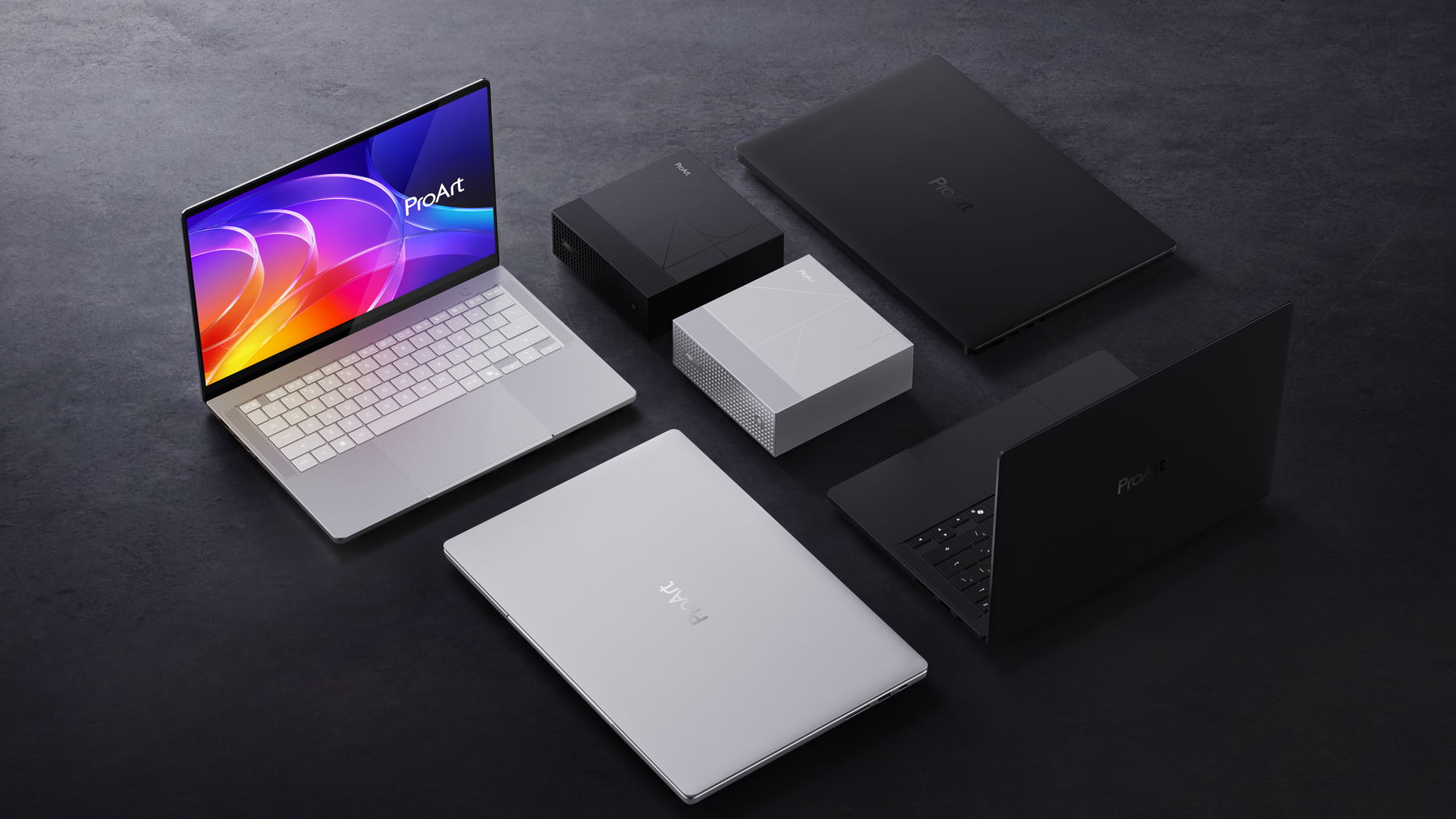 Komputer riba dan komputer mini ASUS ProArt di atas permukaan gelap