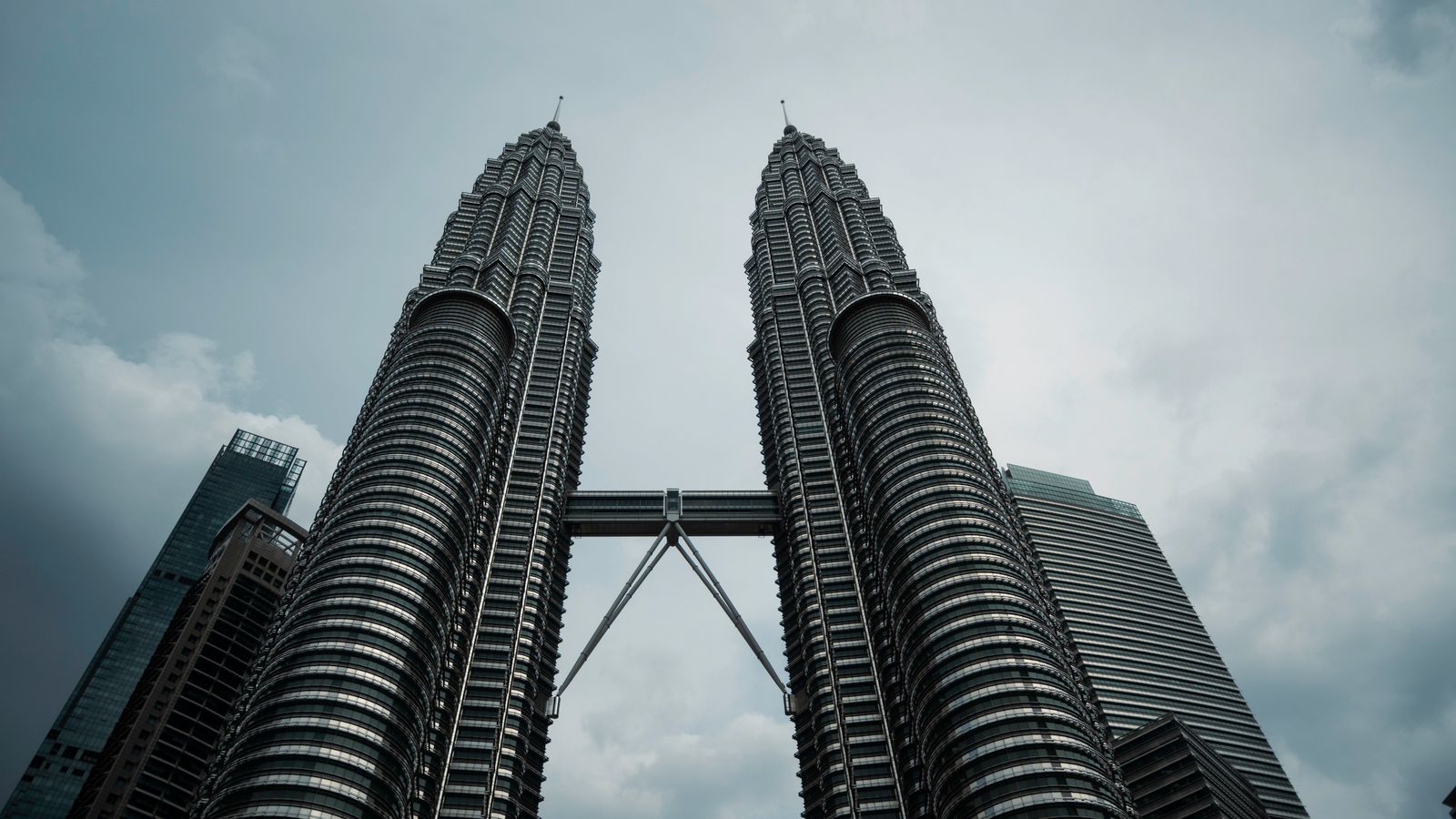 Menara Berkembar Petronas dilihat dari bawah dengan langit mendung