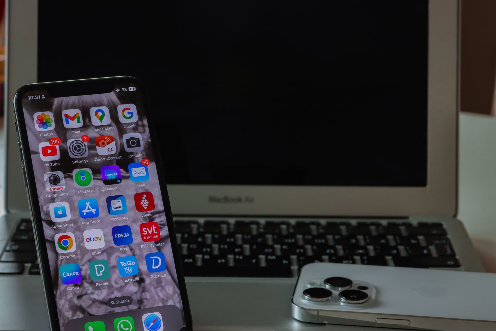 MacBook bersama telefon di meja kerja
