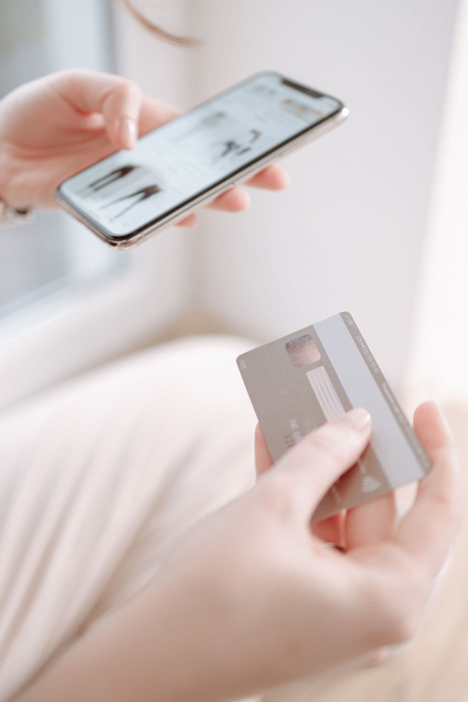 Pengguna memegang telefon dan kad pembayaran