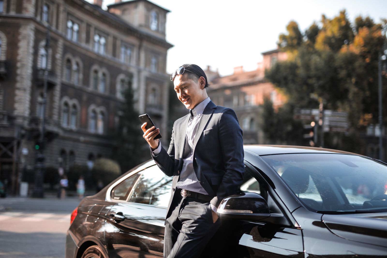 Pengguna melihat telefon di sisi kereta yang diparkir