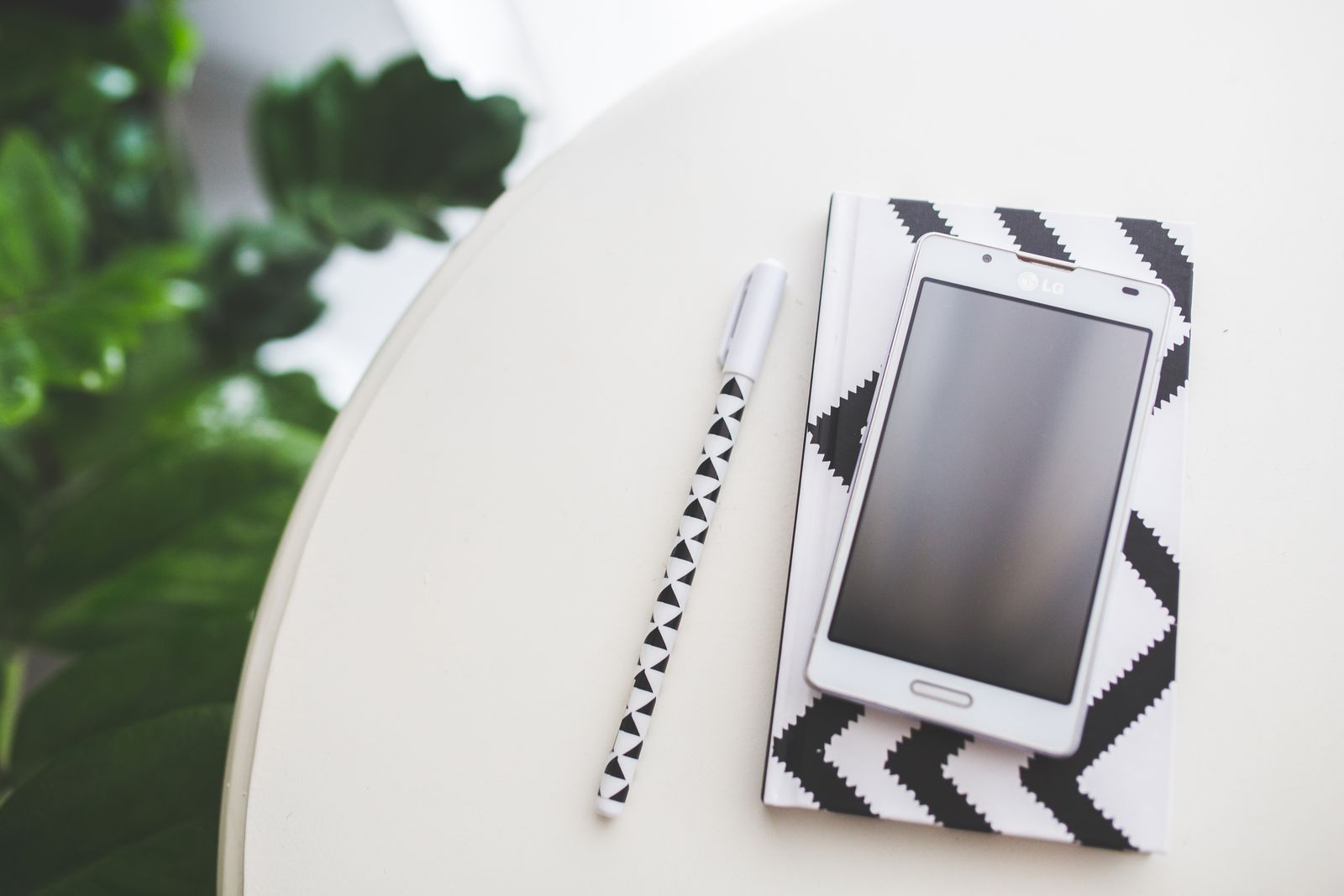 Telefon bersama buku nota dan pen untuk menyusun rutin