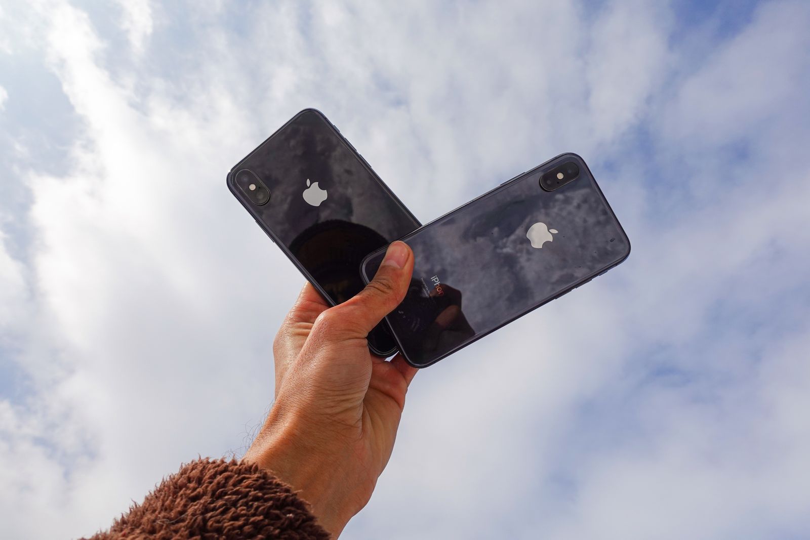 Dua telefon dipegang untuk perbandingan