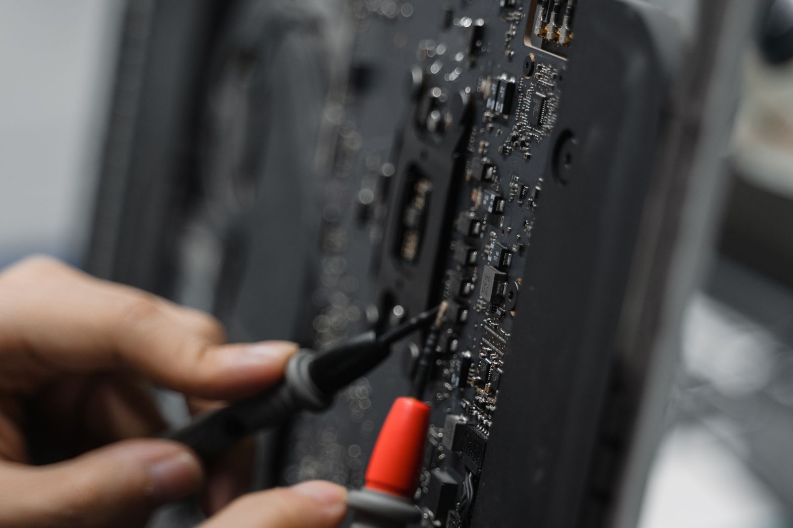 Tangan juruteknik memeriksa komponen elektronik